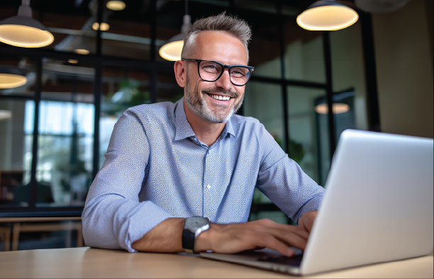 A business professional smiling while working at a laptop